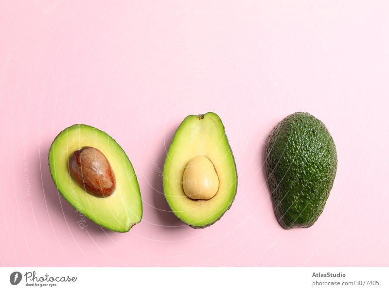 Rip cut avocados with space for text on color background, top view half close exotic slice plant vegetarian backdrop composition ripe summer fruit shape white