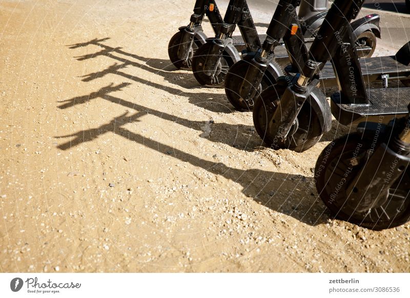 Five E-Scooters Berlin Germany Movement Capital city Summer Town Tourism Logistics Passenger traffic Middle Light Sun Shadow 4 Wheel Deserted Copy Space