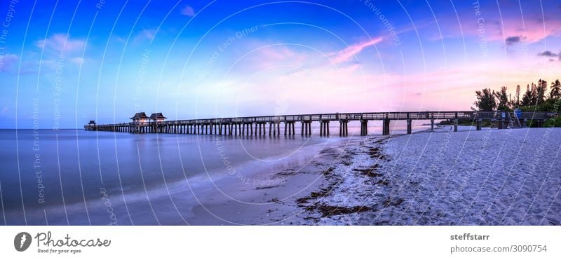 Sunrise over Naples Pier where people fish at dawn in Naples, Beach Ocean Nature Landscape Sky Clouds Summer Coast Blue Pink daybreak Jetty Naples Florida