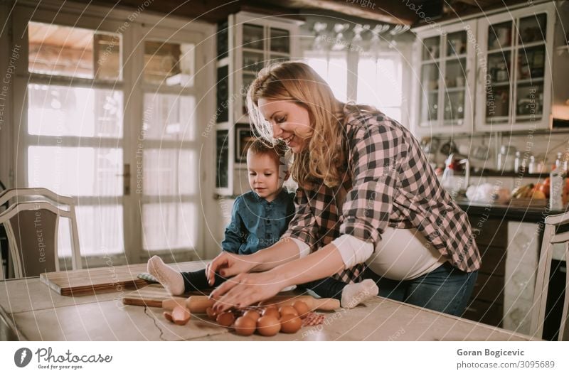 Pregnant woman and little daughter in the rustic kitchen Lifestyle Joy Happy Beautiful Table Kitchen Child Human being Girl Woman Adults Mother