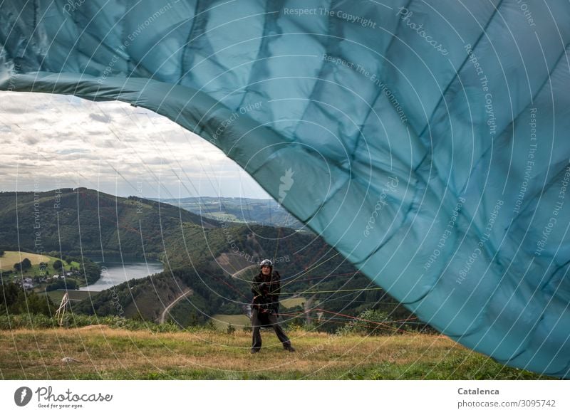 No hang-ups, a paraglider tests the lines on his glider just before takeoff Leisure and hobbies Sports Paragliding Paraglider Nature Landscape Sky Clouds