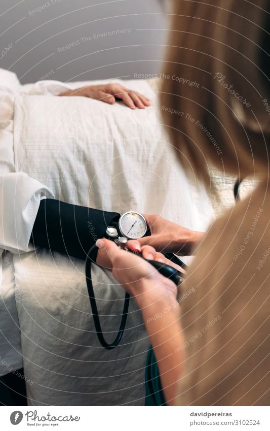 Caregiver checking blood pressure to a senior woman Health care Illness Medication House (Residential Structure) Examinations and Tests Doctor Hospital