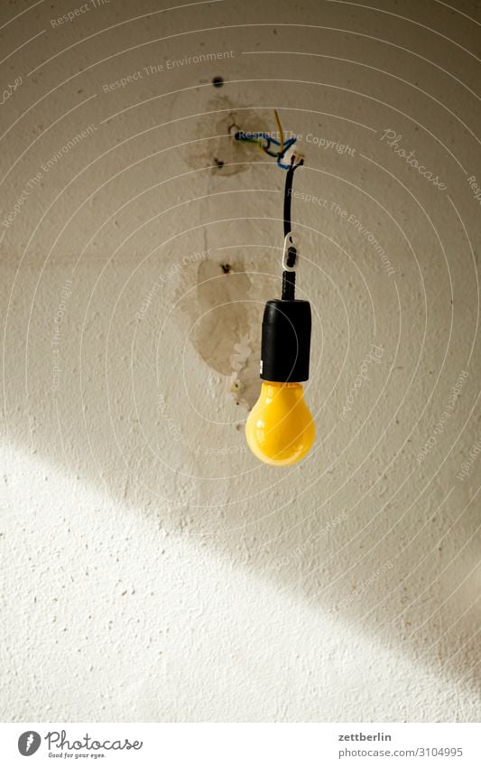 Yellow light bulb Wall (building) Room Interior design Light Shaft of light Dark Awareness Lighting Lamp Electric bulb Colour Traffic light Illuminate Deserted