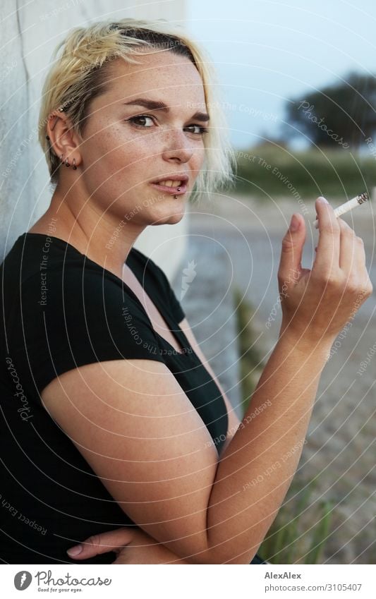 Young woman sitting on a block smoking a cigarette Style Beautiful Youth (Young adults) 18 - 30 years Adults Summer Beautiful weather T-shirt Piercing Blonde