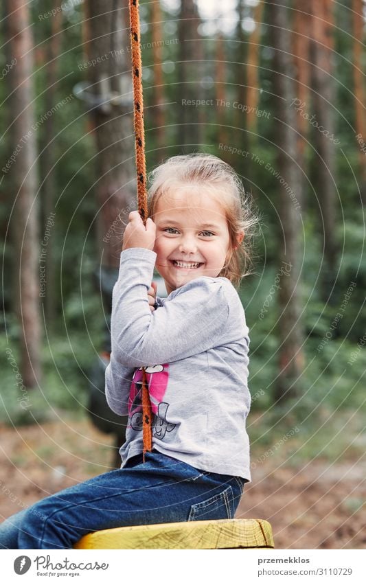 Happy girl riding on the zip line in rope park Joy Playing Vacation & Travel Adventure Summer Child Rope Human being Infancy Park Forest Playground Line Sit