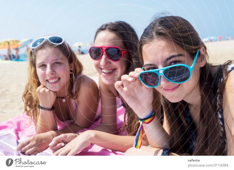 smiling girls best friends lying on beach while looking camera Lifestyle Joy Happy Beautiful Body Face Relaxation Vacation & Travel Summer Beach Ocean