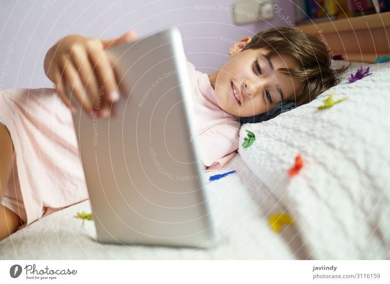 Cute girl using a tablet computer in her bedroom Lifestyle Joy Happy Beautiful Face Leisure and hobbies Playing Bedroom Child School Computer Technology