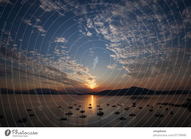 Morning sunrise over a big mountain lake with many boats clouds and reflections Beautiful Calm Leisure and hobbies Summer Sun Ocean Mountain Group Nature