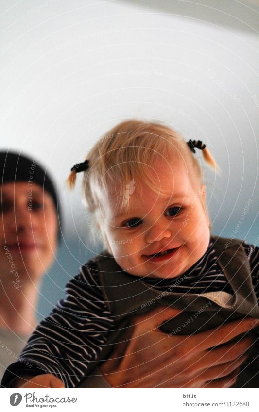 Papa lets his laughing, happy, cheerful daughter with little braids, fly. Child lifted up, in the father's hand, at home in the apartment. Human being Toddler