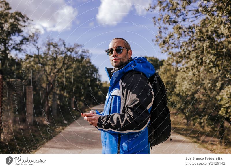 caucasian man using mobile phone outdoors in nature. sunny day Nature Adventure American discovering backpacker traveler Green To enjoy westerner hiker