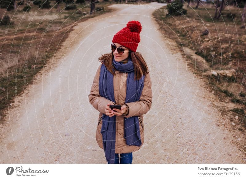 young backpacker woman hiking in nature. Cloudy winter day. Using mobile phone Nature Adventure American discovering traveler Green To enjoy westerner hiker