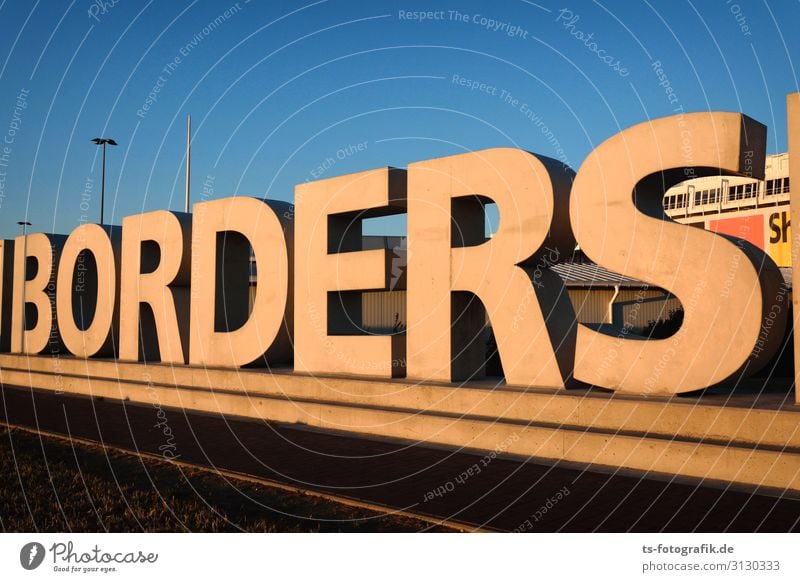 Open borders - The wall is leaking! Architecture Wall (barrier) Wall (building) Stone Sign Characters Signage Warning sign Threat Gigantic Tall Blue Brown