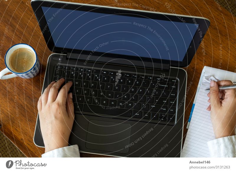 Top view of female using her laptop on a wooden table. Coffee Lifestyle Shopping Leisure and hobbies Desk Table Work and employment Workplace Office Business