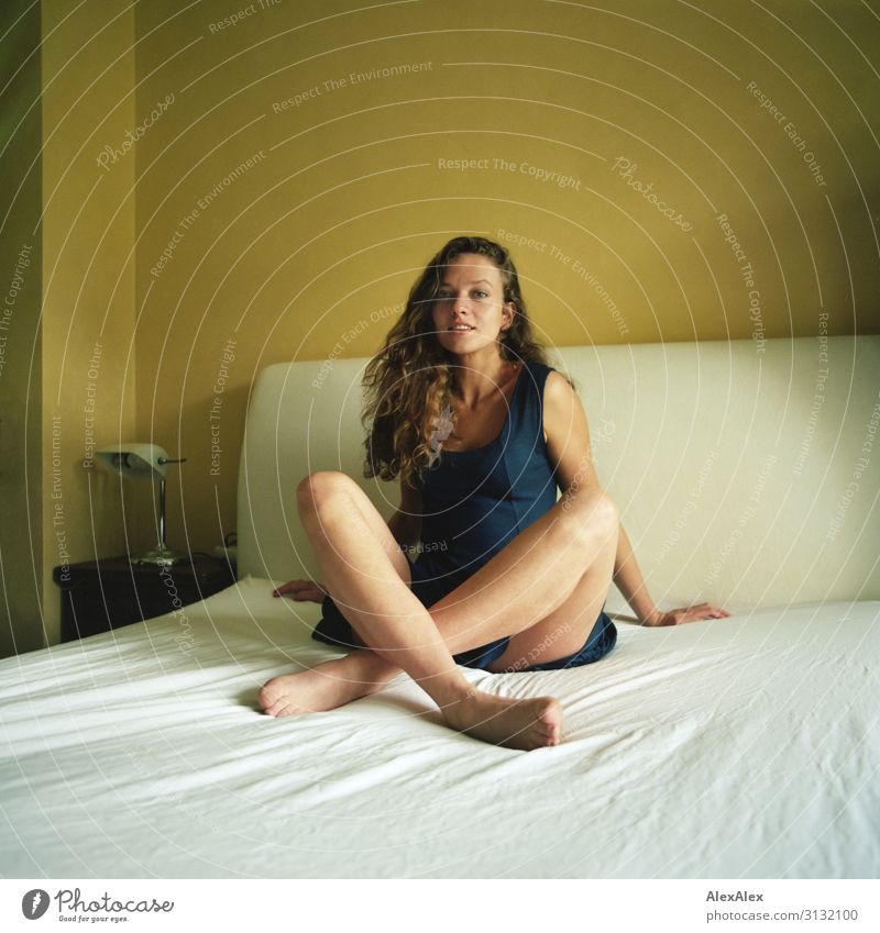 Portrait of a young woman with long legs on a white bed sitting cross-legged Style already Life Flat (apartment) Bed Young woman Youth (Young adults) Legs Model