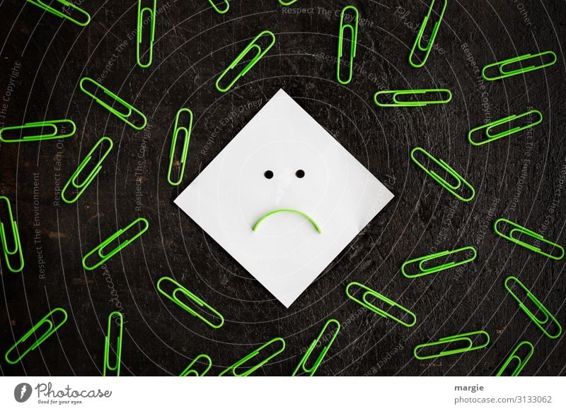 A smiley note surrounded by many green paper clips Work and employment Office work Workplace Green Black White Paper clip Smiley Pessimist Mouth Point Negative