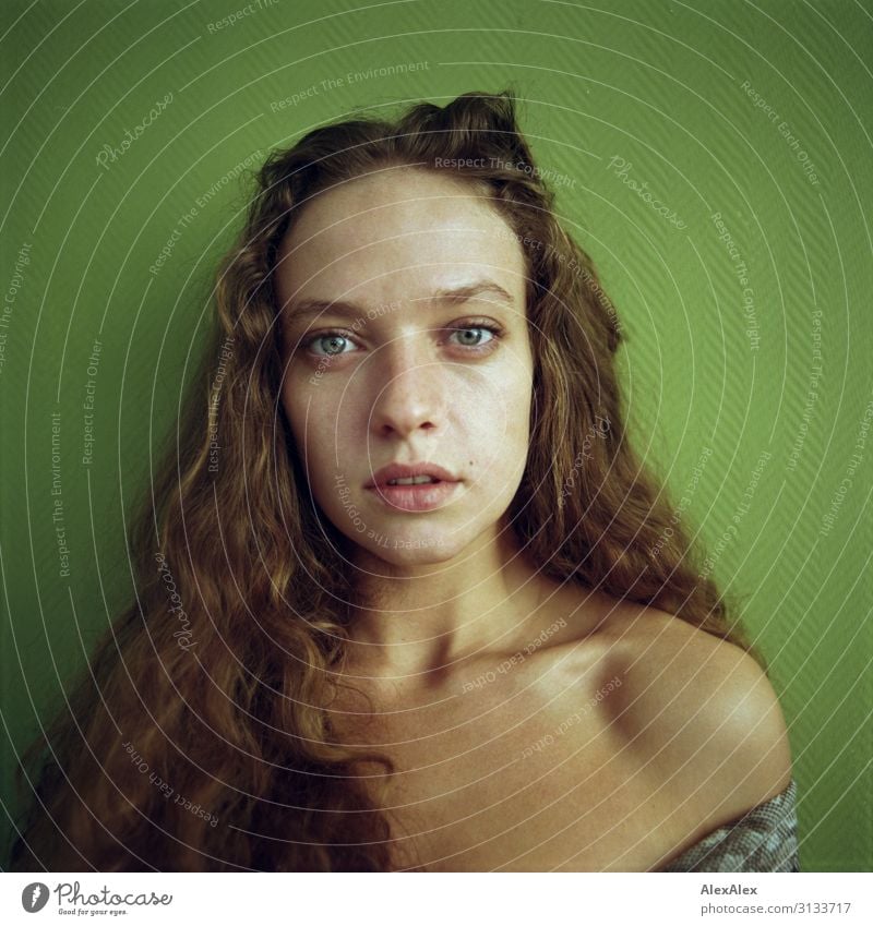 Rectangular portrait of a young woman in front of a green wall Style already Life Young woman Youth (Young adults) Hair and hairstyles Face Model 18 - 30 years