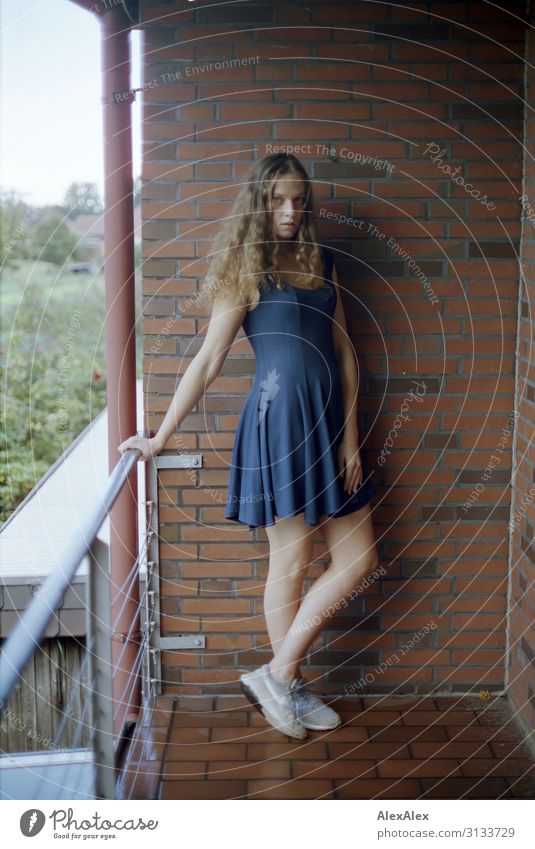 Young woman standing on a balcony of brick wall Lifestyle Style already Well-being Living or residing Balcony Brick wall Handrail Youth (Young adults)