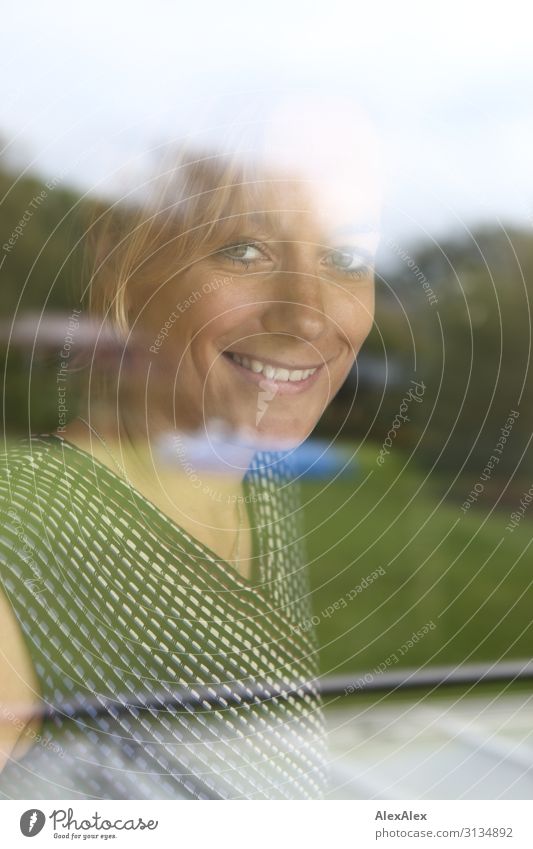 Portrait of a young woman behind a window Lifestyle Elegant Style Joy pretty Harmonious Living or residing Garden Window Pane Young woman Youth (Young adults)