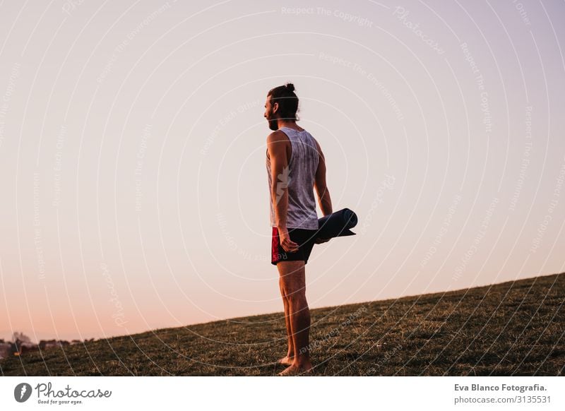 young man in a park ready to practice yoga sport. city background. healthy lifestyle. Concentrate Position Human being Youth (Young adults) Body Park Man