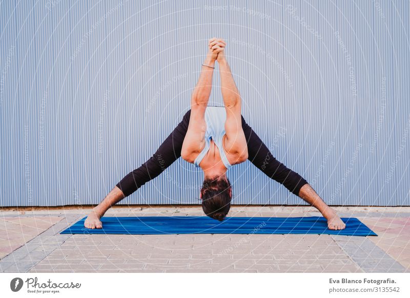 man in the city practicing yoga sport. blue background. healthy lifestyle Blue background Yoga Man City Town Lifestyle Muscular Concentrate Position Human being