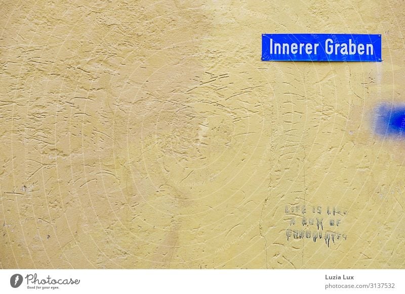 Inner Trench axe semolina Small Town Wall (barrier) Wall (building) Street Looking Blue Yellow Wisdom street sign Graffiti Subdued colour Exterior shot Deserted