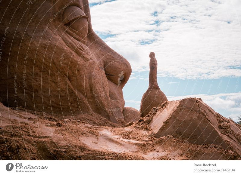 David and Goliath Clouds Sand To talk Success Gigantic Small Blue Orange Optimism Power Brave Trust Unwavering Belief Sculpture Colour photo Exterior shot