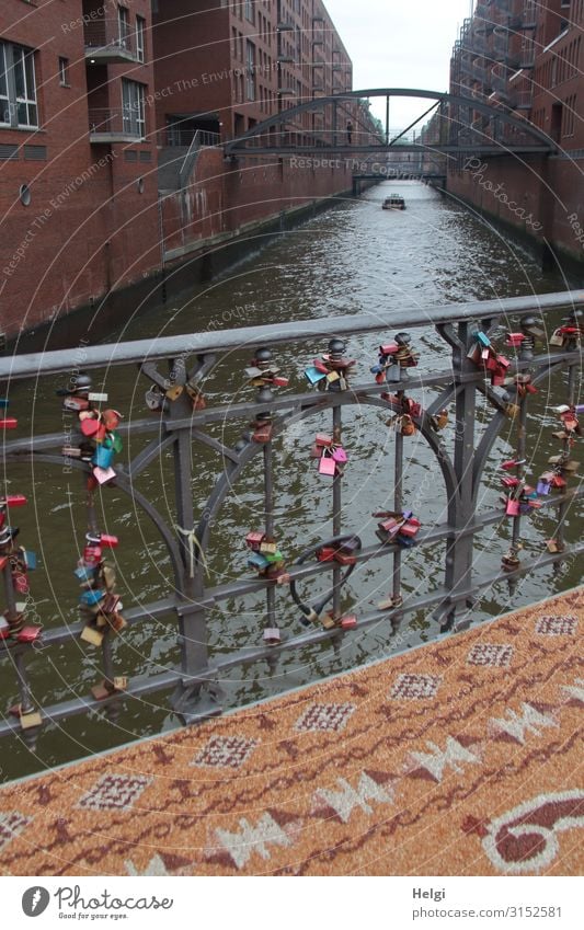 Bridge railing with many love palaces, in front of it a patterned carpet of small stones in the Speicherstadt Hamburg Water Port City Building Architecture