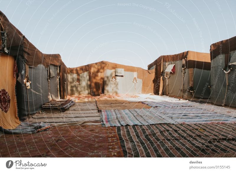 Berber tent camp with clothes and carpets, in Sahara desert Lifestyle Exotic Vacation & Travel Trip Camping Sun Culture Drought Morocco Africa Places