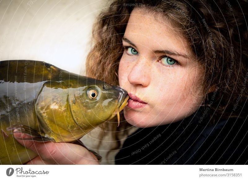 Young woman with impressive green eyesvkissing a carp, fish Seafood Dinner Lifestyle Happy Beautiful Face Fishing (Angle) Human being Feminine Woman Adults