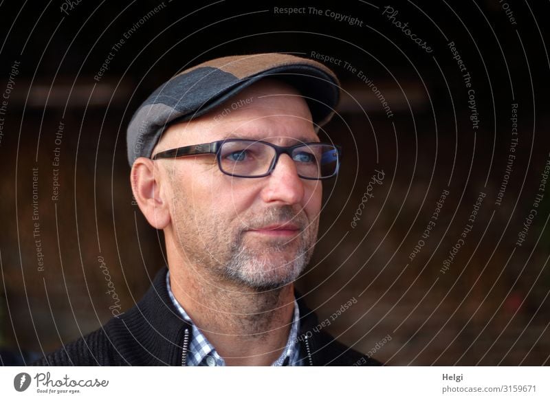 Portrait of a man in half profile with beard, glasses and cap against a dark background Human being Masculine Man Adults Male senior Senior citizen Head Face 1