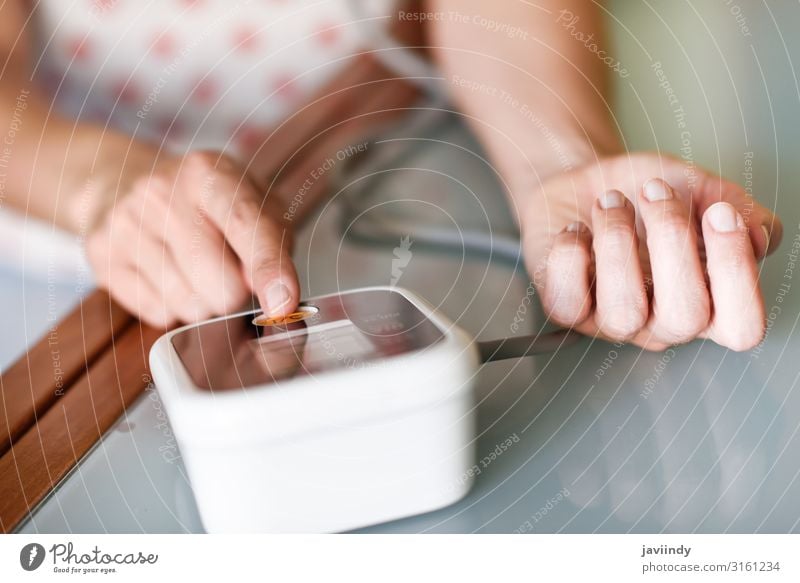 Woman measuring her own blood pressure at home. Health care Illness Medication Examinations and Tests Screen Tool Human being Feminine Young woman