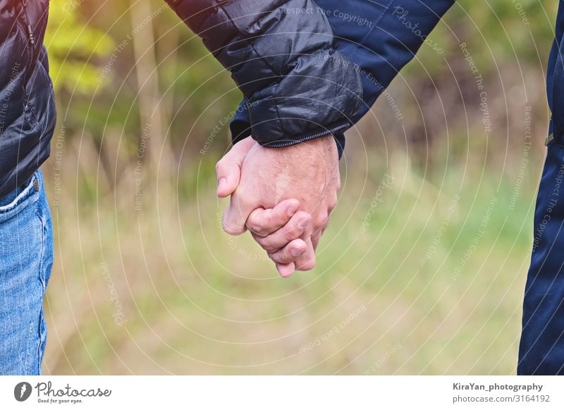 Two men holding hands in jackets outdoor, closeup view, copy space Lifestyle Happy Beautiful Freedom Feasts & Celebrations Human being Homosexual Boy (child)