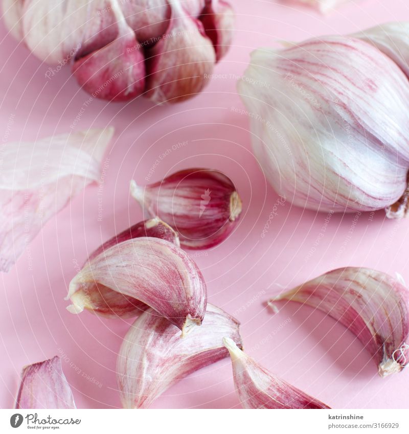 Fresh garlic on a light pink background Vegetable Herbs and spices Vegetarian diet Decline Garlic bulb ingrerient Clove food health healthy Organic Raw Minimal