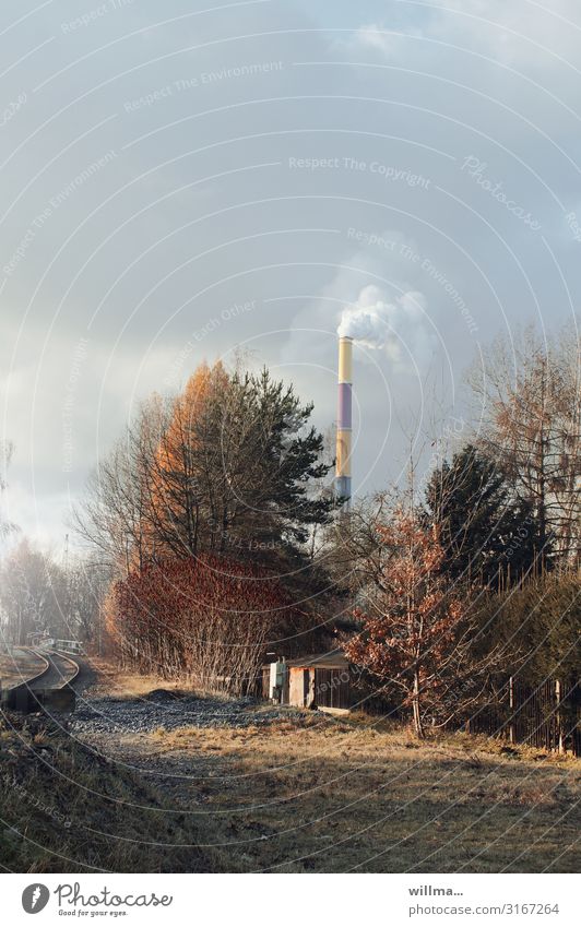 Autumnal impression of a city outskirts with smoking chimney Bushes Tree Meadow Railroad tracks Chimney Smoke Thermal power station overcast sky