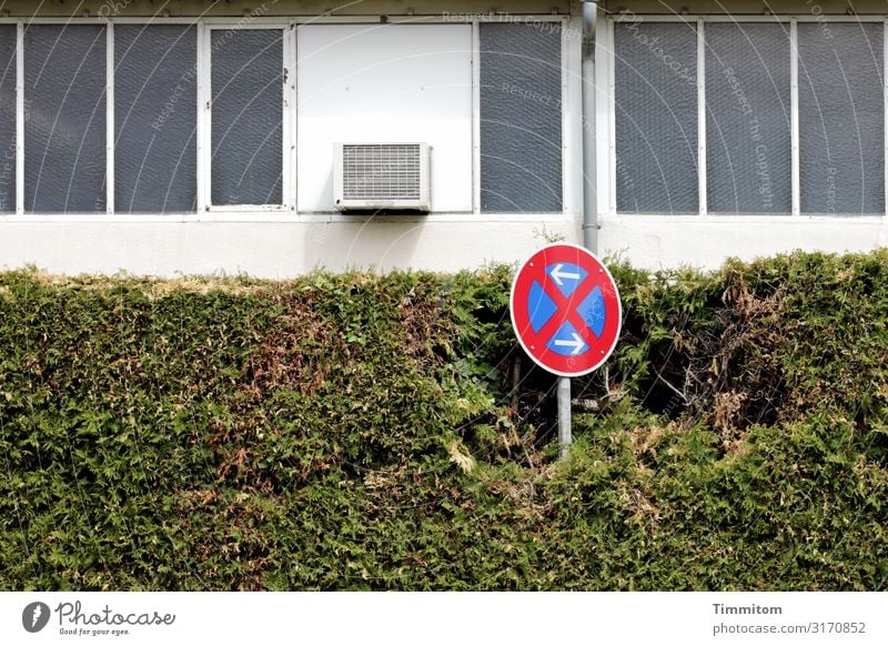 Traffic sign, strong Hedge Town Industrial plant Facade Window Transport Road sign Concrete Glass Metal Sign Signs and labeling Blue Green Red White