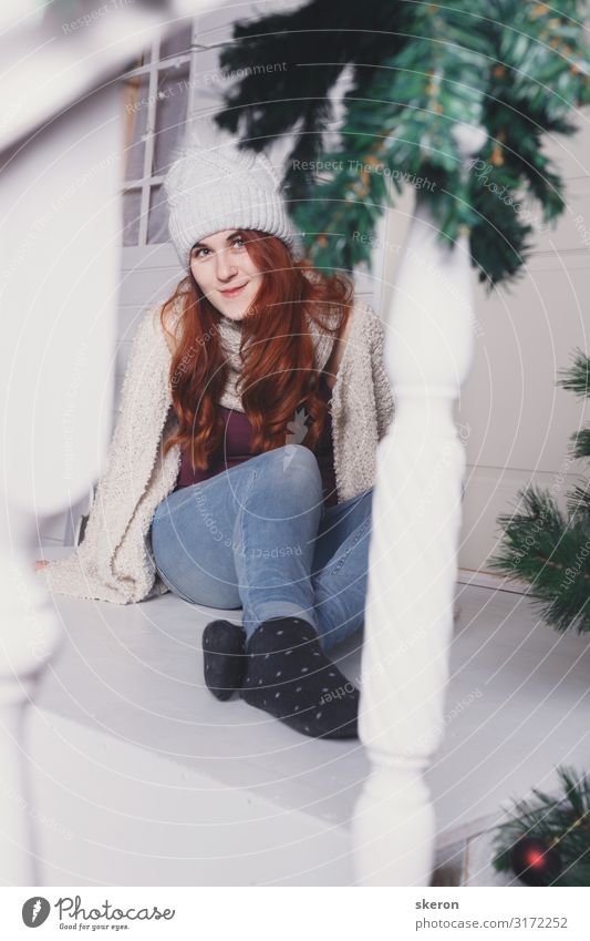 girl in a winter hat sits on the porch of a Christmas house Lifestyle Shopping Leisure and hobbies Entertainment Party Event Christmas & Advent New Year's Eve