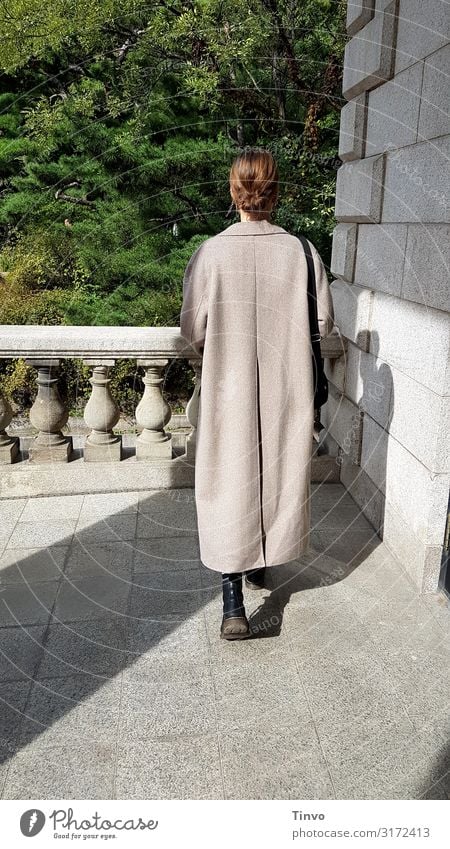 Rear view of a young woman in a long coat on an old balcony Young woman Coat Balcony Romeo and Juliet historical building Colour photo Exterior shot Building