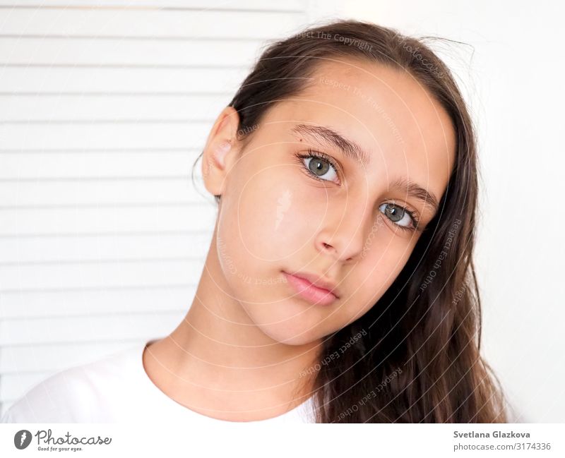 Portrait of a beautiful young caucasian tanned girl on a white background closeup. Brown long health hair. Calm face, beauty concept Lifestyle Style Beautiful