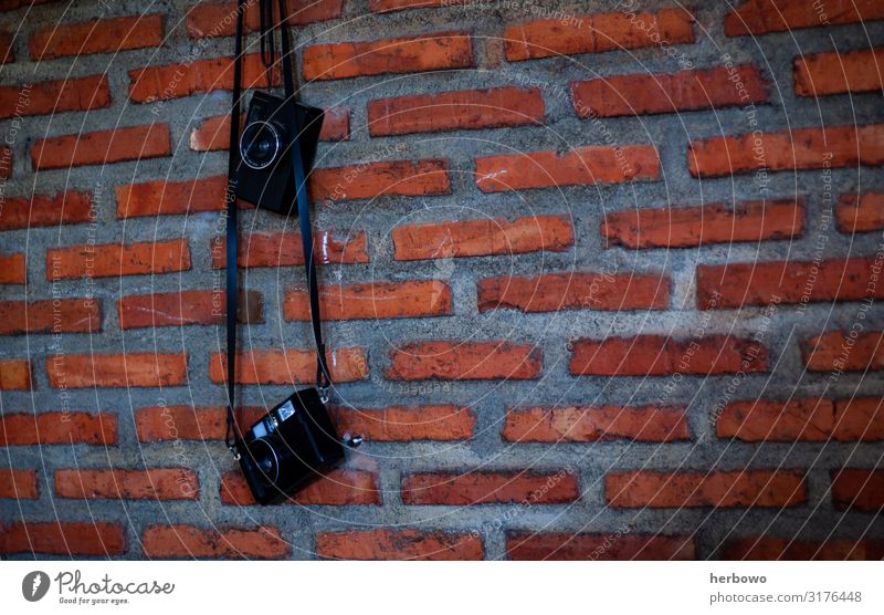 camera hanging on brick wall Wallpaper Camera Wall (barrier) Wall (building) Decoration Brick Brown Gray Orange Red Moody Colour photo Interior shot Day Light