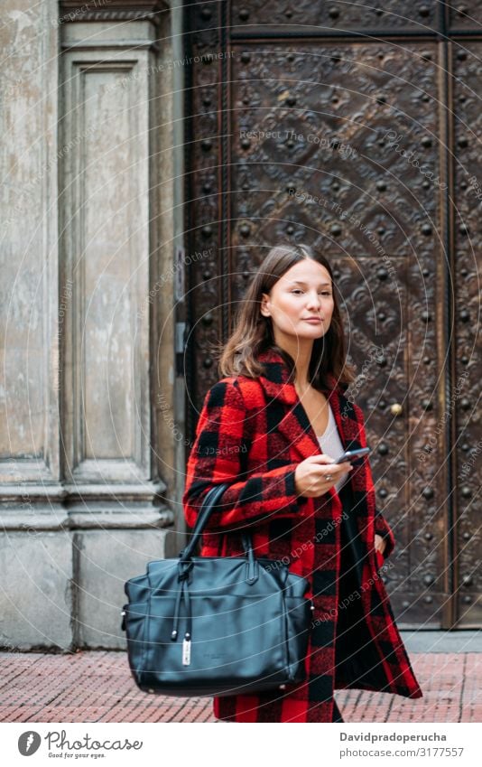 pretty young woman walking on the street using smartphone cell technology smile daylight looking away device gadget conversation outdoors city tail cheerful