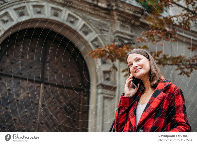 pretty young woman walking on the street using smartphone cell technology smile daylight looking away device gadget conversation outdoors city tail cheerful