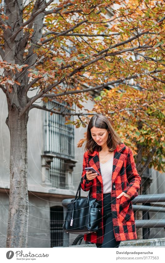 pretty young woman walking on the street using smartphone cell technology smile daylight looking away device gadget conversation outdoors city tail cheerful