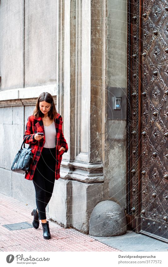 pretty young woman walking on the street using smartphone cell technology smile daylight looking away device gadget conversation outdoors city tail cheerful