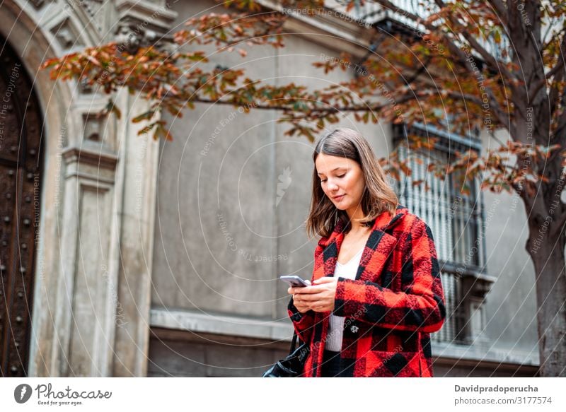 pretty young woman walking on the street using smartphone cell technology smile daylight looking away device gadget conversation outdoors city tail cheerful