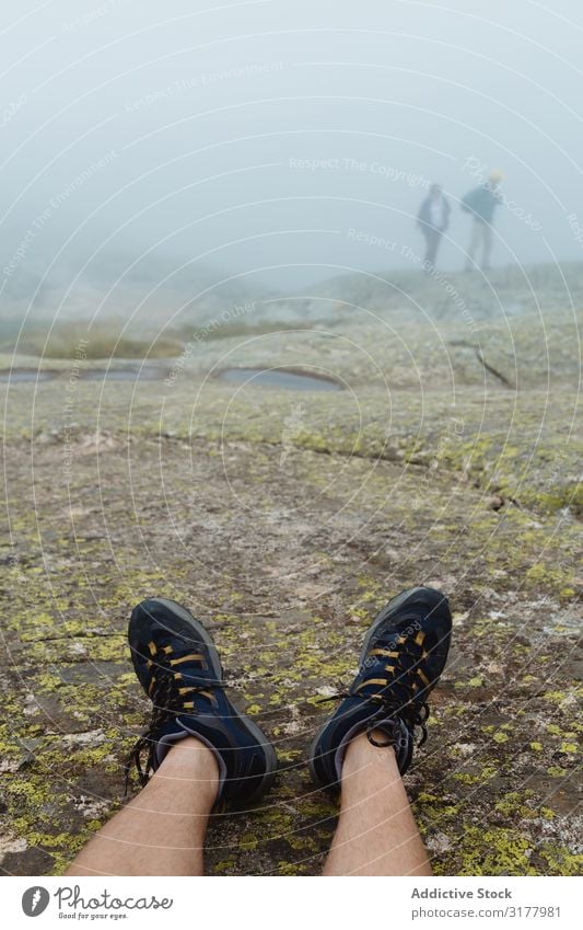 Crop legs on stony ground on misty day Legs traveler Fog Ground Stone Landscape Nature Trip Relaxation Sneakers Hiking trekking Adventure Rock Rough Vague Haze