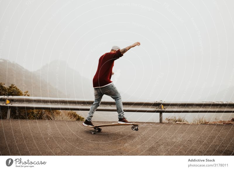 Trendy skateboarder doing trick in nature Man Skateboard Mountain Trick Street Ride Longboard Jump Fog Landscape Remote Panorama (Format) Skateboarding Practice