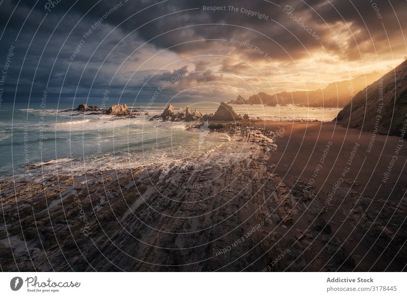 Picturesque seaside with rocks at bright sunset Sunset Rock Bright Beach Clouds Rain Stone Wave Landscape Vantage point Nature Beautiful Coast scenery Water