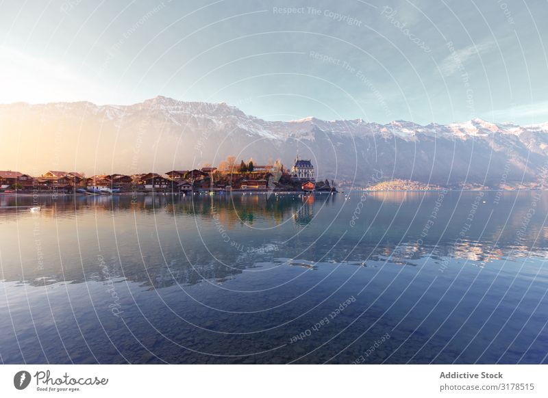 Tranquil lake with boats on pier against mountains Landscape Lake Jetty Mountain Switzerland Nature Sunlight Town Peace Idyll Vacation & Travel Reflection