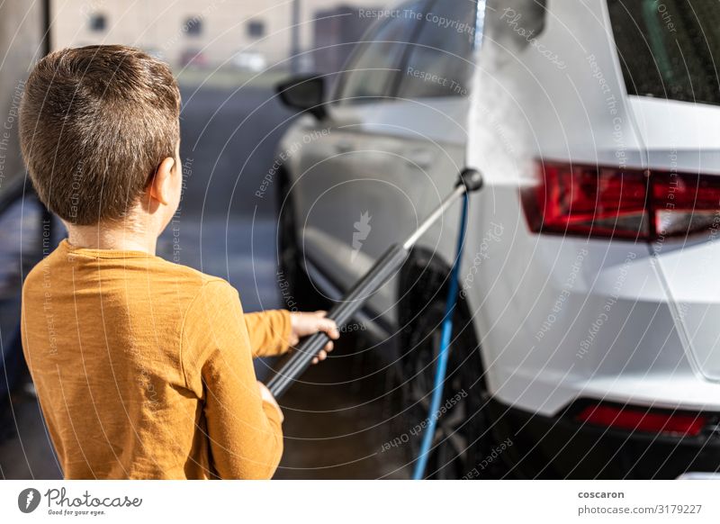 Little kid cleaning a car with a high pressure hose Lifestyle Joy Happy Beautiful Leisure and hobbies Trip City trip Summer Garden Child Schoolchild Business