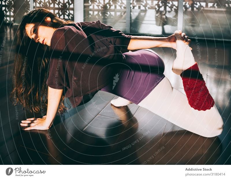 Ballerina dancer warming up flexible body in sunny studio. Woman Stretching Practice Sports Ballet Dancer pose Action stretch Beauty Photography Interior shot